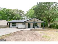 Charming renovated home with a covered front porch and new black metal roof at 6532 Voyles Dr, Riverdale, GA 30274
