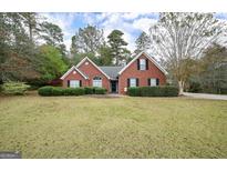 Charming brick home features well-manicured landscaping, inviting curb appeal, and a classic design at 95 Blue Grass Ct, Oxford, GA 30054
