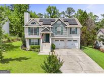 Charming home with a two-car garage, solar panels, and a well-manicured front yard at 103 Manx Dr, Grantville, GA 30220