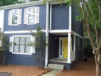 Charming blue two-story home with white trim, shutters, and a bright yellow front door at 1023 Falling Water Se Dr, Smyrna, GA 30080