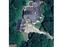 An aerial view of a home featuring multiple windows and dark roofing surrounded by a dense tree line at 145 E Lake Dr, Mountain Park, GA 30075