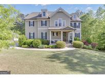 Traditional two-story home with a manicured lawn, dormer windows and inviting covered front porch at 335 Discovery Lake Dr, Fayetteville, GA 30215