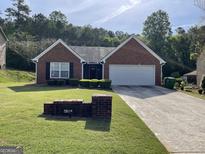 Charming brick home featuring a well-maintained lawn and driveway at 4092 River Mist Ct, Lithonia, GA 30038