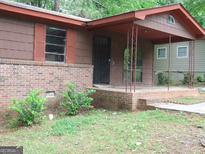 Modest one-story home featuring brick foundation and covered porch with support beams at 6154 Green Acres Sw Dr, Covington, GA 30014