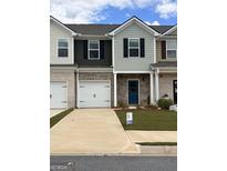 Charming townhome featuring brick facade, white garage doors, and manicured lawn at 8714 Lakeview Commons # 48, Jonesboro, GA 30238