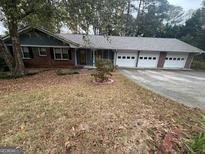 Charming one-story home with a brick facade and an attached three-car garage at 1329 Springwood Nw Dr, Conyers, GA 30012