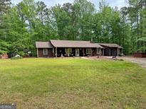 Inviting single story house with a well-maintained lawn and mature trees providing ample shade at 712 Honeysuckle Ln, Temple, GA 30179