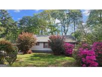 Charming home with beautiful landscaping, colorful azaleas, and mature trees, offering great curb appeal at 402 Emmett St, Riverdale, GA 30274
