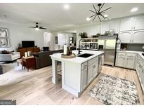Bright kitchen with island seating, stainless steel appliances, light cabinets, and open floor plan at 109 Old Virginia Cir, Jonesboro, GA 30236