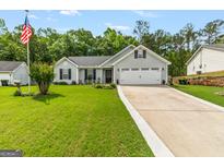 Charming home featuring manicured lawn, gray siding, black shutters, and a two-car garage at 12 Connie Trl, Grantville, GA 30220