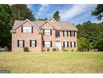 Charming two-story brick home with black shutters, well-manicured lawn, and classic architectural details at 105 Kellens Ct, Fayetteville, GA 30215
