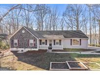 Charming home featuring stone facade, inviting front porch, and landscaping at 84 Contour Dr, Stockbridge, GA 30281