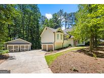 Charming home with a detached garage, lush landscaping, and a welcoming entrance at 760 Swan Ln, Canton, GA 30115