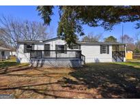 Charming single-story home featuring a covered porch and freshly painted white siding and black shutters at 152 Skyland E Dr, Locust Grove, GA 30248