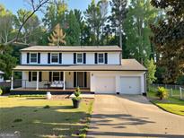 Charming two-story home boasts a manicured lawn, welcoming porch, and convenient two-car garage at 2691 Old South Dr, Jonesboro, GA 30236