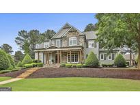 Charming two-story home with stone accents, a welcoming front porch, and beautifully landscaped front yard at 400 Conservatory Pt, Fayetteville, GA 30215