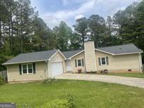 Charming single-story home with a well-maintained lawn and a classic suburban aesthetic at 625 Locust Rd, Locust Grove, GA 30248