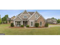 Charming single-Gathering home featuring stone accents, a manicured lawn, and a welcoming front porch at 2076 Towne Mill Ave, Canton, GA 30114