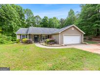 Charming single-story home with a well-maintained lawn, blossoming landscaping, and an attached two-car garage at 3775 Highway 16 E, Sharpsburg, GA 30277