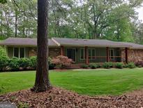 Ranch style home featuring a combination of stone and painted siding, set on a wooded lot with mature trees at 205 Aberdeen Dr, Peachtree City, GA 30269