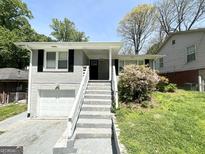 Charming home with brick and lush landscaping with a stairway leading up to the covered entry at 1417 Lavender Nw Dr, Atlanta, GA 30314