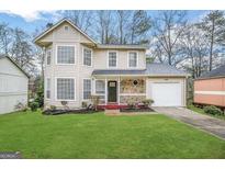 Charming two-story home with well-manicured lawn and cozy front porch with stone accents at 2717 Knollberry Ln, Decatur, GA 30034