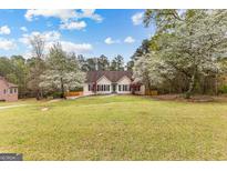 Charming home with a manicured lawn and flowering trees on a sunny day at 195 Blackberry Run, Fayetteville, GA 30214
