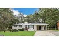 Charming ranch-style home featuring a well-maintained lawn and a covered carport at 6507 Jackie Ln, Austell, GA 30106