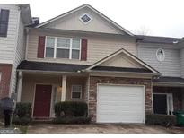 Charming two-story townhome with stone accents and an attached garage at 1255 Chinon Pt, Lithonia, GA 30058