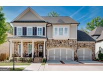 Charming two-story home featuring a stone and siding facade, complemented by a cozy front porch at 10140 Grandview Sq, Duluth, GA 30097
