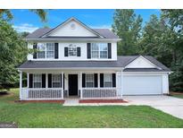Charming two-story home with a welcoming front porch, black shutters, and a well-maintained lawn at 145 Tara Way, Covington, GA 30016
