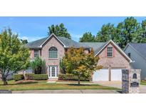Charming two-story brick home with a manicured lawn, two-car garage, and well-maintained landscaping at 655 Wildboar Ct, Fairburn, GA 30213
