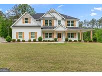 Stunning two-story white home with wood shutters and columns showcasing great curb appeal and a well-manicured lawn at 152 Creekrise Pl, Palmetto, GA 30268