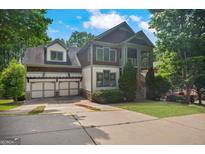 Charming home with a three-car garage, well-manicured lawn, and inviting covered front porch at 2548 Kickerillo Se Way, Atlanta, GA 30316