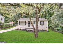 Charming one-story home with black shutters, green lawn and mature trees at 830 Mercury Dr, Atlanta, GA 30331