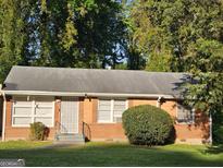 Charming brick home with a well-maintained lawn and mature trees offers great curb appeal at 1990 Shamrock Dr, Decatur, GA 30032