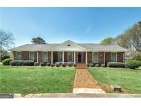 Charming brick ranch-style home with a well-manicured lawn and a brick walkway leading to the front door at 1092 E Lake Rd, Mcdonough, GA 30252
