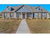 Charming single-story home featuring a brick facade, dormer windows, and well-maintained landscaping at 1141 Abundance Dr, Locust Grove, GA 30248