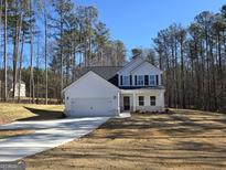 Charming two-story home with a modern design, attached garage, and a well-manicured lawn in a wooded neighborhood at 746 S. Bethany Rd., Locust Grove, GA 30248