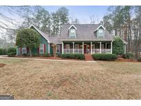 Charming two-story home with a welcoming front porch and mature landscaping at 4186 Highway 138 Sw, Stockbridge, GA 30281
