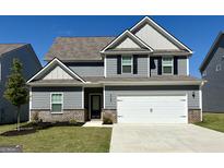 Charming two-story home with a gray exterior, two-car garage, well-maintained lawn, and beautiful brick accents at 438 Prescott Way, Villa Rica, GA 30180