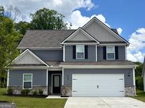 Charming two-story home featuring a gray exterior, attached two-car garage, and well-manicured lawn at 425 Prescott Way, Villa Rica, GA 30180