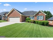 Charming brick home with well-manicured lawn and two-car garage at 375 Oakpark Ter, Mcdonough, GA 30253