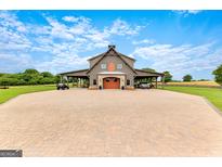 Stunning exterior view of barn with covered parking and large driveway with brick pavers at 290 Weldon Rd, Fayetteville, GA 30215