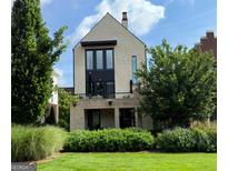 Modern two-story home featuring brick facade, balcony, large windows, and a well-manicured lawn at 145 Kelmscott Ln, Fayetteville, GA 30214