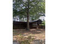 Rustic home featuring a large wrap-around porch, offering an inviting space to relax in a secluded, wooded setting at 3255 Flat Shoals Sw Rd, Conyers, GA 30094