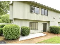 Charming townhome featuring a well-manicured lawn and tidy landscaping with an inviting facade at 1448 Pine Log Ne Rd # C, Conyers, GA 30012