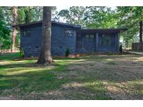 Charming one story home with dark painted brick exterior and lush front yard at 1147 Tanglewood Rd, Jonesboro, GA 30236