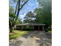 Charming brick ranch home with a well-maintained lawn and covered parking area at 9163 Fair Sw St, Covington, GA 30014