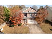Charming two-story brick home featuring a well-maintained lawn and mature trees at 1281 Heartwood Ave, Mcdonough, GA 30253